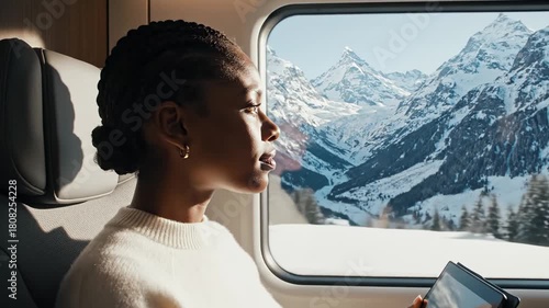 Young Black woman looking thoughtfully out the window during winter travel. Alpine Reflection.