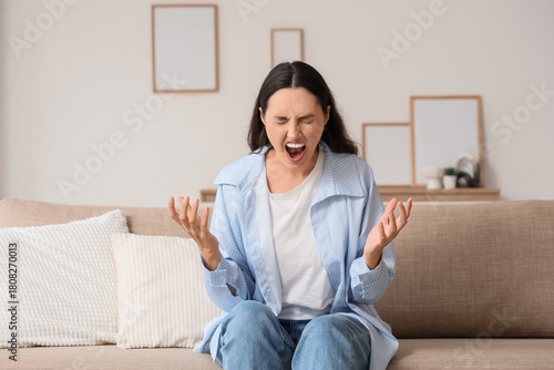 Screaming young woman sitti...