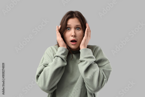 Foto Scared young woman on light background