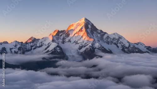 Snow-covered mountain peak illuminated by golden sunrise alpenglow, capturing a powerful yet peaceful natural landscape ideal for travel, adventure and inspirational stock imagery.