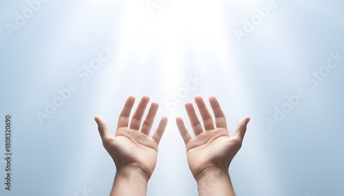 Two hands reaching toward a radiant white light, symbolizing freedom, unity, hope and human rights in a clean, uplifting stock photography style.