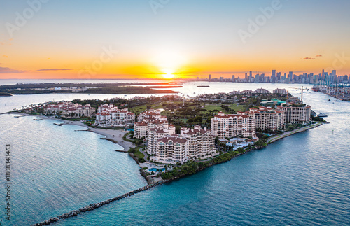 Aerial view of Fisher Island Miami at sunset with city skyline.