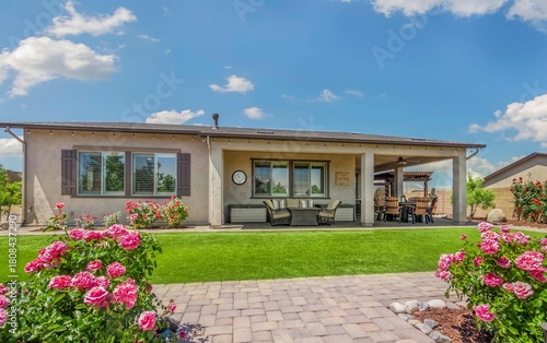 A house with a large lawn and colorful flowers in front