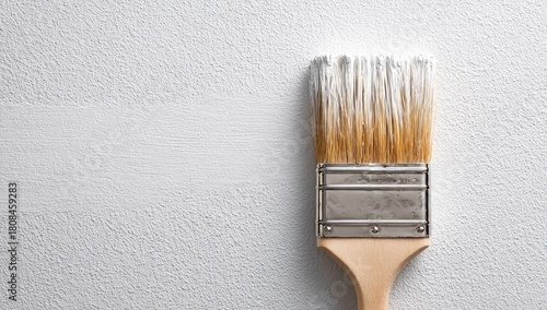 Paintbrush with white paint, textured wall