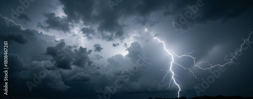 Dramatic thunderstorm with lightning striking dark cloudy sky  