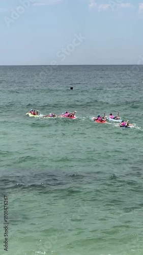 group of kids at a surf lifesaving event, racing on boards outdoors at a beech in Australia