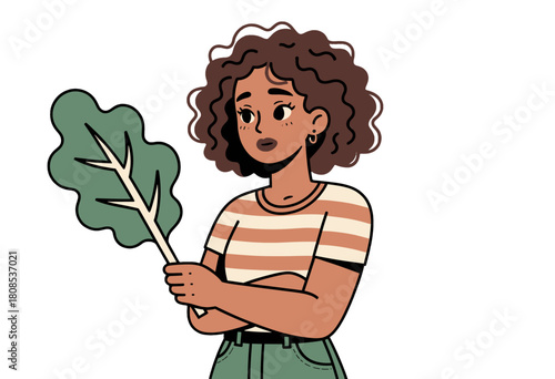Curly-haired woman holding a large green leaf
