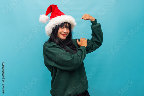 Confident woman in Santa hat flexes her arm proudly Ideal for strong Christmas character and empowerment themes