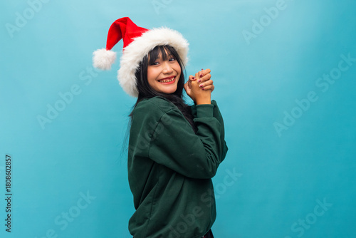 Joyful woman in Santa hat claps hands cheerfully Ideal for Christmas celebration and fun festive visuals