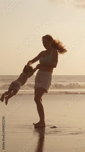 Mother Spinning Child by Hands on Beach at Sunset, Ocean Silhouette, Love and Joy, Family Happiness, Parenting Bond, Warm Light and Freedom, Emotional Moment of Motherhood and Childhood Connection