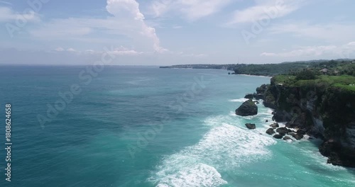 Aerial view of coastal cliffs and sea spray.