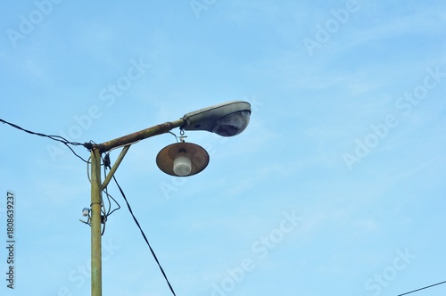 Old Street Lamp and Electrical Wires Against Blue Sky