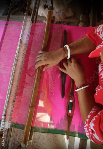 Handloom weaver working on loom.