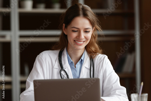 Female doctor smiles while having video consultation on laptop, showcasing professional and friendly demeanor. setting is warm and inviting, emphasizing modern healthcare environment