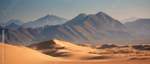 AI-generated image - A wide desert landscape with soft golden sand dunes and rugged mountains in the distance, captured in warm natural light for a serene and dramatic atmosphere.