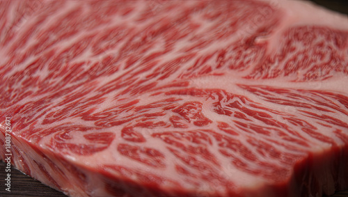 A close-up view of a premium wagyu beef cut highlights the delicate marbling and rich texture. The beef's glossy surface glistens, emphasizing its quality and freshness
