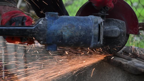 Workers are sawing rebar on concrete with a saw blade on an autumn day