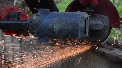 Workers are sawing rebar on concrete with a saw blade on an autumn day