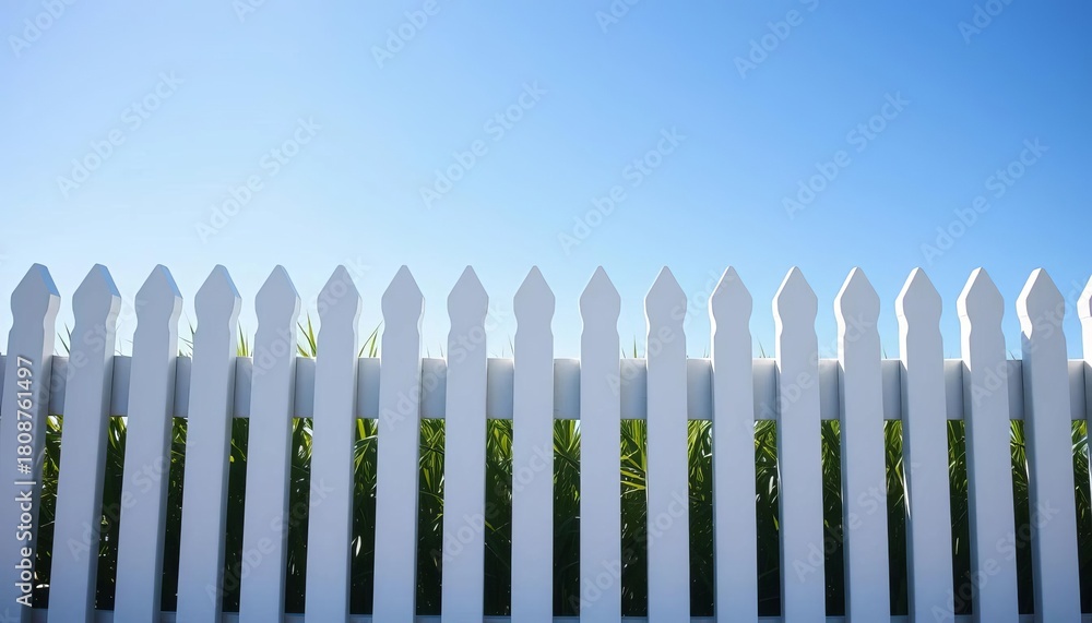 Obraz premium Clean white picket fence against bright blue sky, garden, fence