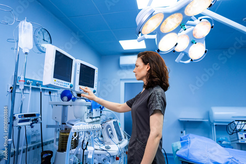 Doctor using medical monitor. Surgeon adjusting vital signs equipment during procedure prep