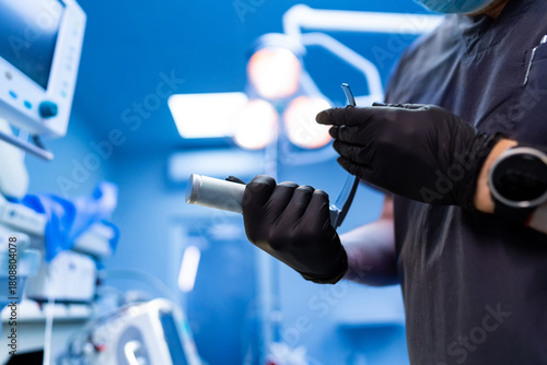 Doctor preparing medical tool. Doctor preparing metal medical tool inside bright modern OR.