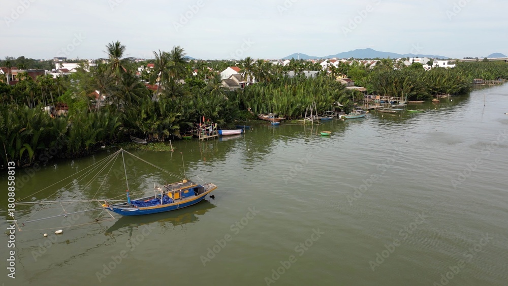 Obraz premium Asia, Vietnam , Hoi An Daily life flows slowly on the Thu Bon River with fishing boats with nets and trawlers - Hoi An the city of lanterns, a UNESCO World Heritage Site