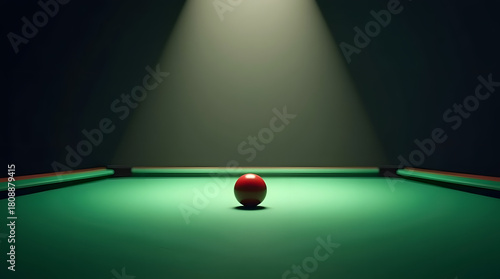 A solitary red billiard ball on a green pool table illuminated by a spotlight, creating a dramatic atmosphere.