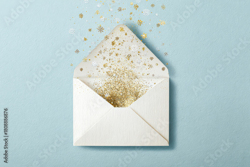 Festive envelope overflowing with golden glitter and snowflakes for holiday celebrations