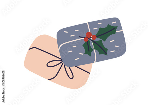 Gift boxes in holiday paper wrapping with bow and holly berry decorations. Wr...