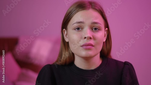 young white woman close-up teary in pink-lit bedroom delivering vulnerable confession and apology, soft cushions blurred background, subtle glistening tears,