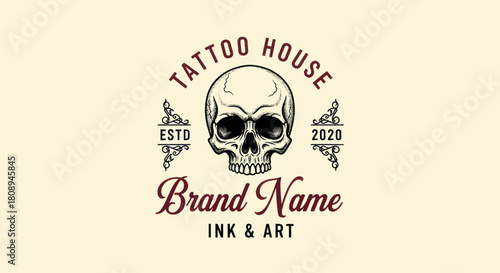 Vintage-style human skull emblem for a tattoo house brand, with decorative elements and establishment year.