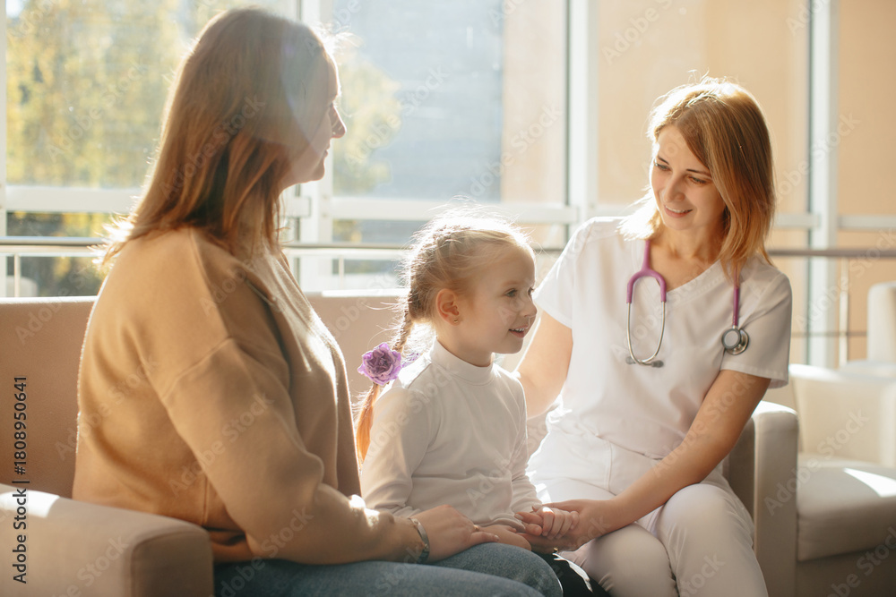Obraz premium Pediatrician reassuring young girl at clinic appointment