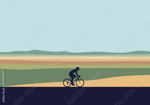 Cyclist riding in scenic landscape with colorful horizon silhouette