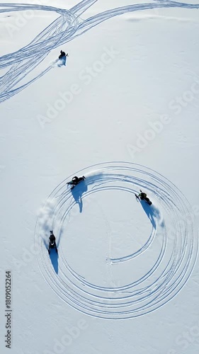 Snowmobilers Create Circles on Snowy Field Drone Footage