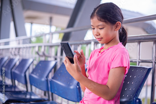 Young Girl Using Smartphone While Sitting in Public Area