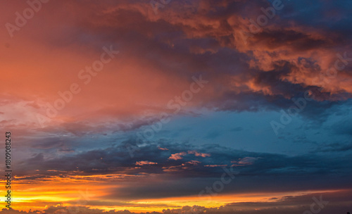 Dreamlike sunset sky filled with glowing colors above calm, layered clouds