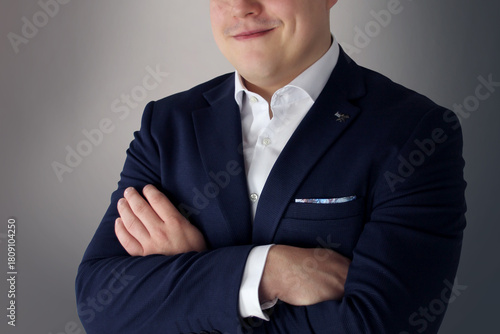 Close-up confident businessman in navy suit, subtle smile, white shirt, Emotional reaction, embracing life, studio lighting, grey background, professional portrait