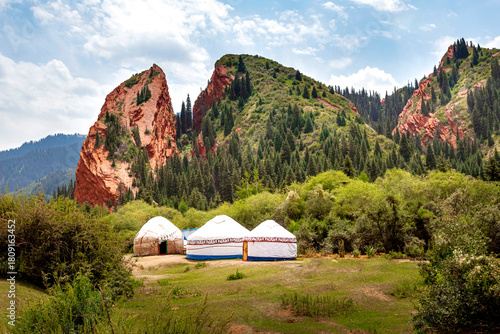 Broken Heart red cliffs in the Jeti-Oguz gorge Kyrgyzstan with white yurts in the foreground