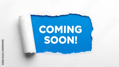 coming soon paper tear. coming soon text message revealed through ripped white paper on a bright blue background announcement concept