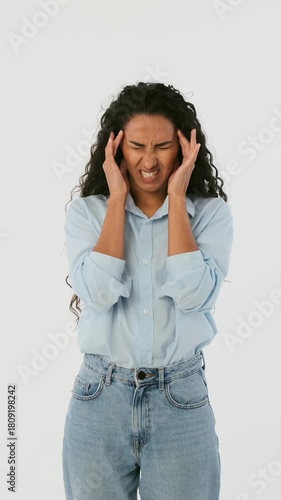 Stressed young woman touching temples and suffering from headache. Unhappy female feeling migraine, pain or stress isolated on white background.