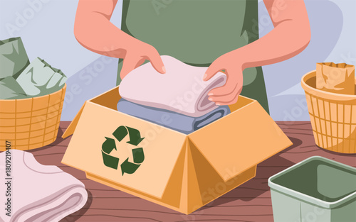 Person folding clothes into a recycling box with a green recycle logo on the side