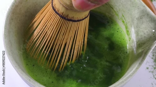 Process making matcha green tea. Mixing matcha tea with whisk in wooden bowl. Healthy matcha drinks