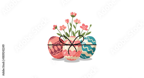 Three beautifully decorated easter eggs in pastel colors tied with a simple black ribbon with delicate pink flowers blooming from the center.
