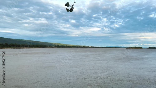 Windy with Silhouette of Peepal Leafs on the Branches, Landscape Riverside Mekong River. Record Video at Temple, Khai Si, Bueng Kan, Thailand. 03Nov2025, P.M./ Real Time Video