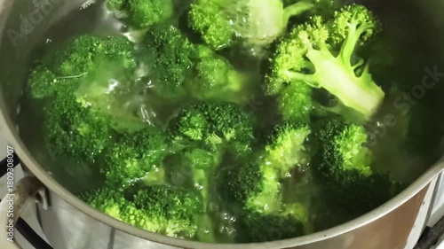 Fresh broccoli branches during cooking in stainless steel pot