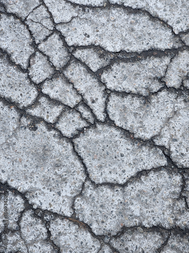 Fototapeta premium Cracked asphalt surface. Creative cracked background. Old asphalt