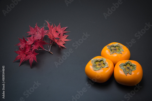 美しく紅葉したもみじの葉と秋の代表的な果物の柿