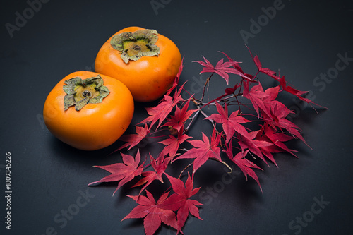 美しく紅葉したもみじの葉と秋の代表的な果物の柿