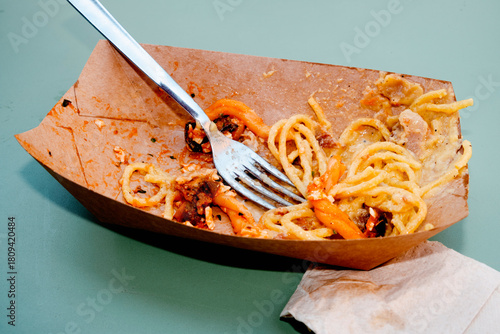 cardboard box with pasta leftovers on a table