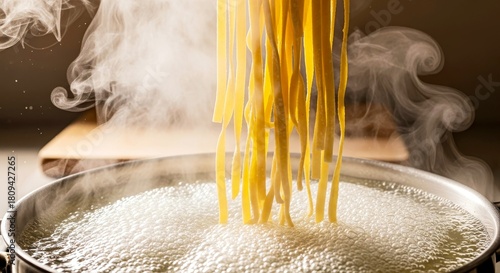 Hot pasta noodles being cooked in boiling water with steam rising  